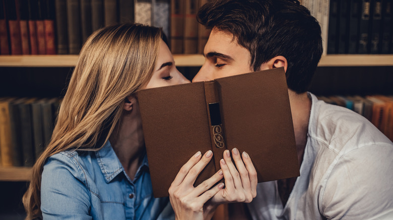 couple kissing behind an open book