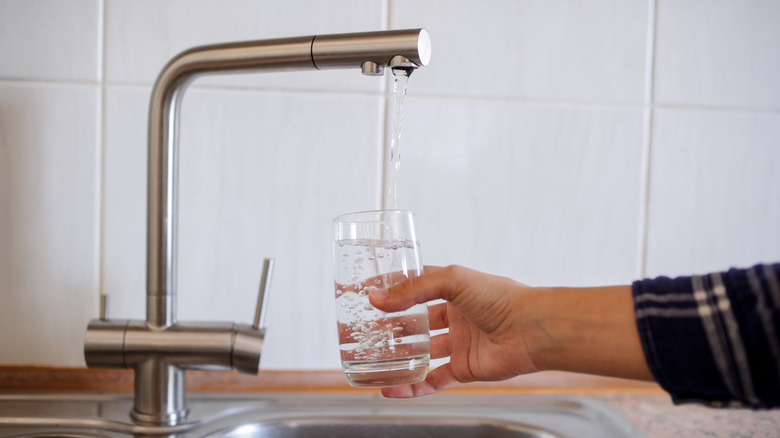 someone filling a glass with water