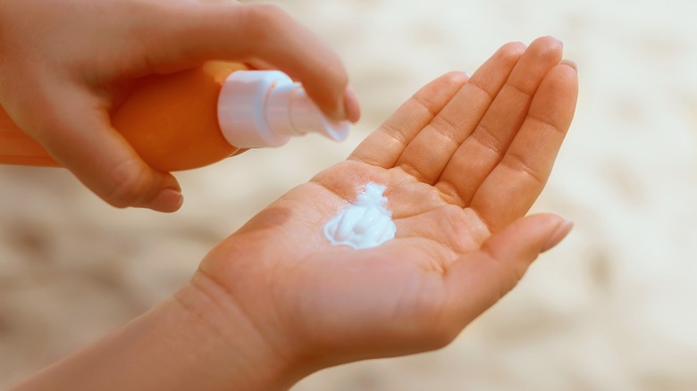 person adding moisturizer to hand