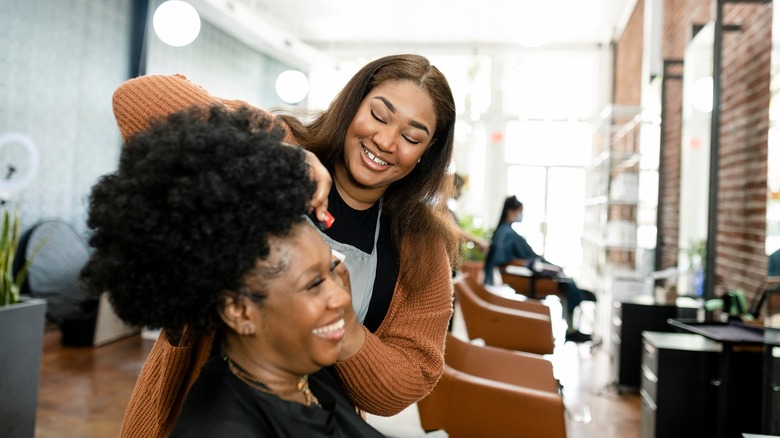 A hair stylist styling her client's hair