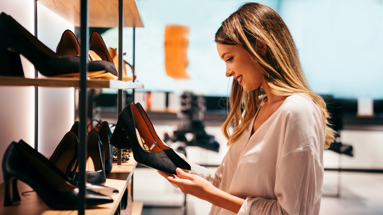 Woman perusing row of shoes inside store