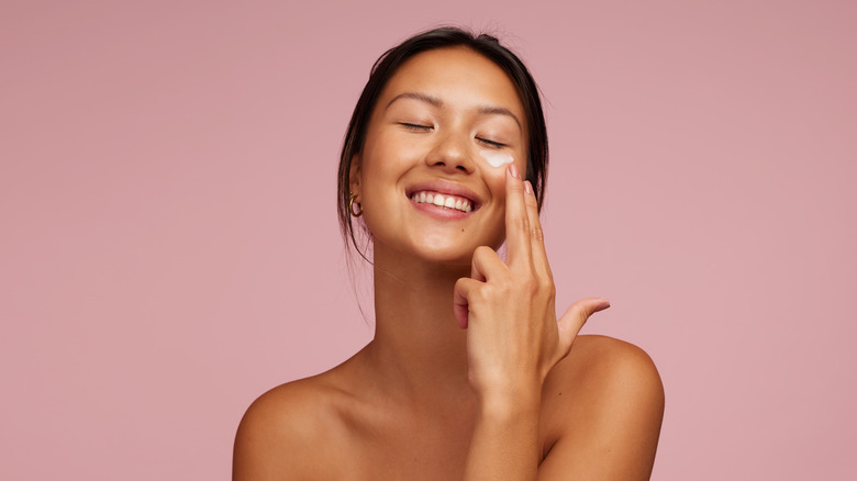 Woman smiling putting on makeup