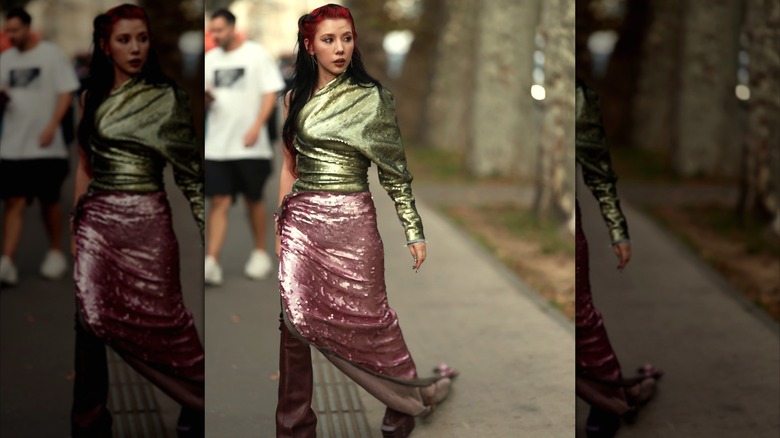 Woman wearing sequined green top and pink skirt