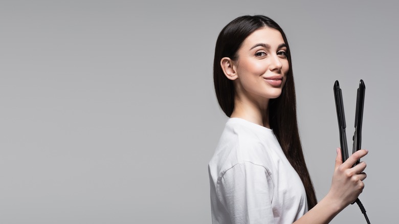 woman holding hair straightener