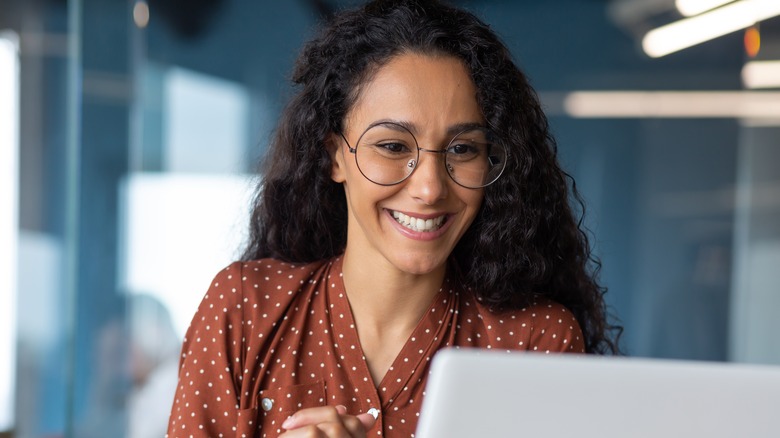woman smiling at computer screen