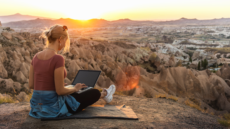 woman with laptop in mountains