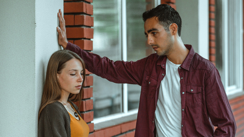 Man leaning close to unhappy woman