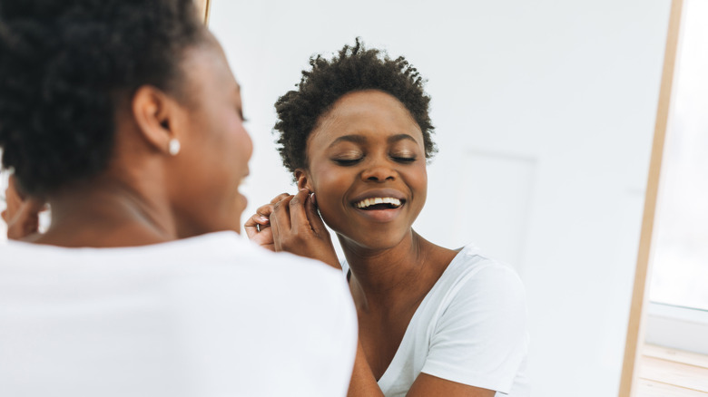 Woman putting earring in