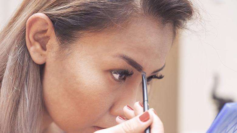 Woman applying brow powder