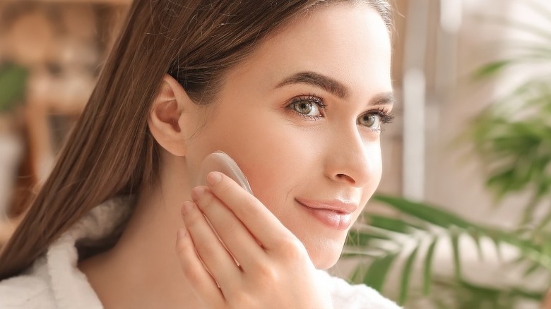 Woman applying makeup to her cheek