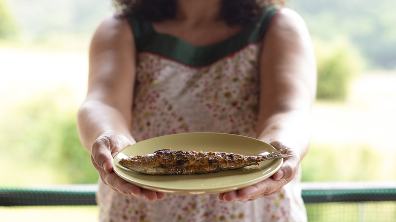 Woman holding a large sardine