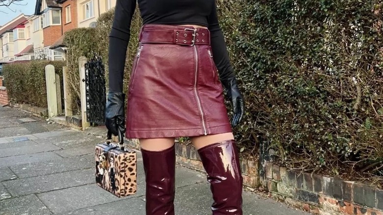 Woman wears leather skirt with multiple zippers