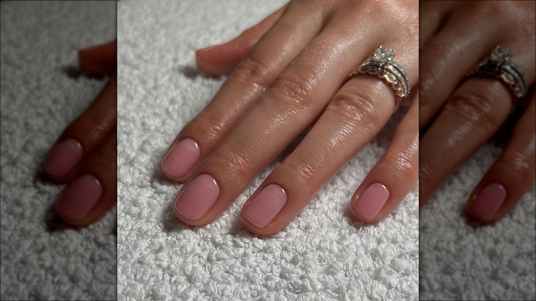 hand with sheer pink nails at short length