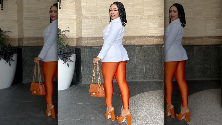 Instagram user @houseofatl in orange leggings and heels