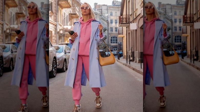 Woman wearing pink sweatsuit and lilac trench