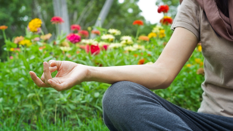 Person meditating in flower garden