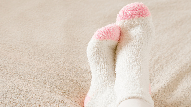 Model wearing white and pink fuzzy socks