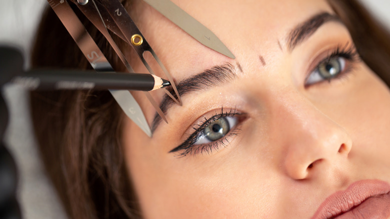 Brow arch tool used on woman's brows