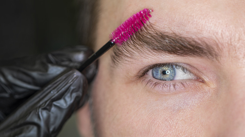 Man applying brow gel