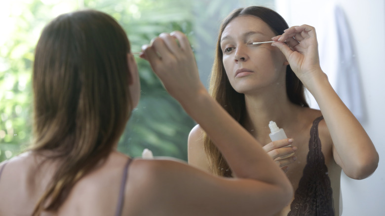 woman applying lash serum