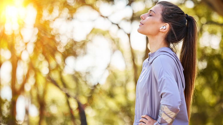 Woman standing outside with headphones