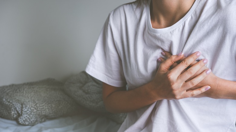 woman holding heart in bed 