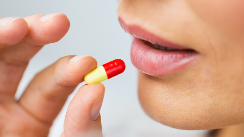 woman taking antibiotic pill 