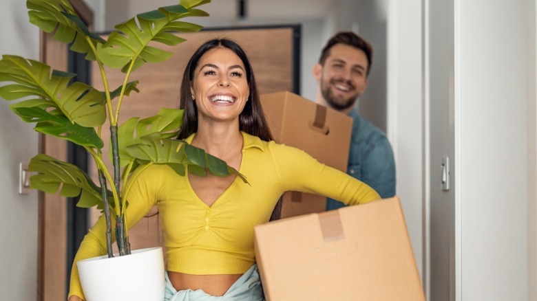 Woman and man carrying belongings