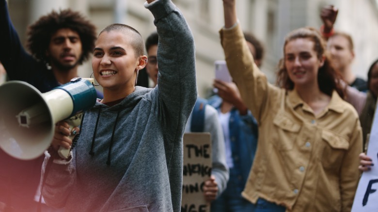 People marching in protest with bullhorn and signs