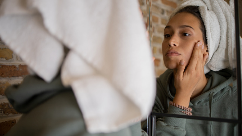 Woman applies moisturizer to face 