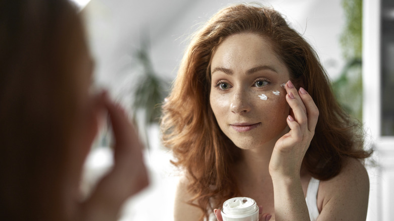 Woman applying skincare cream