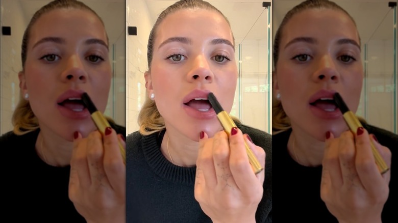 Sofia Richie Grainge applying lip balm 