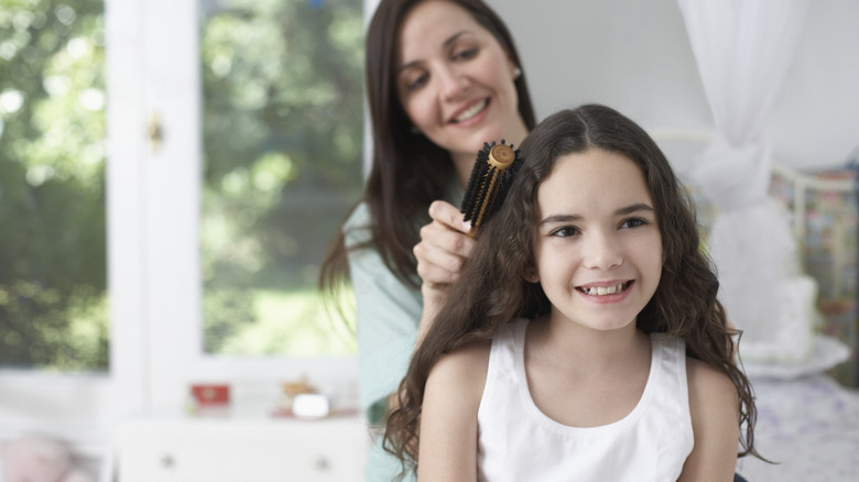 A mother styling her daughter's hair