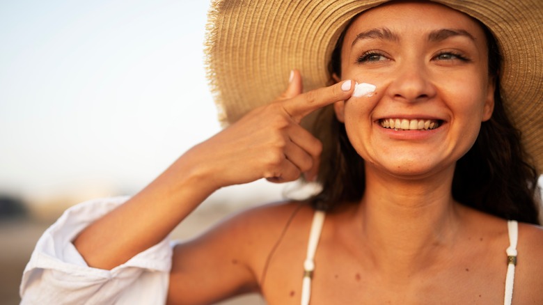 Woman applying sunscreen to her face