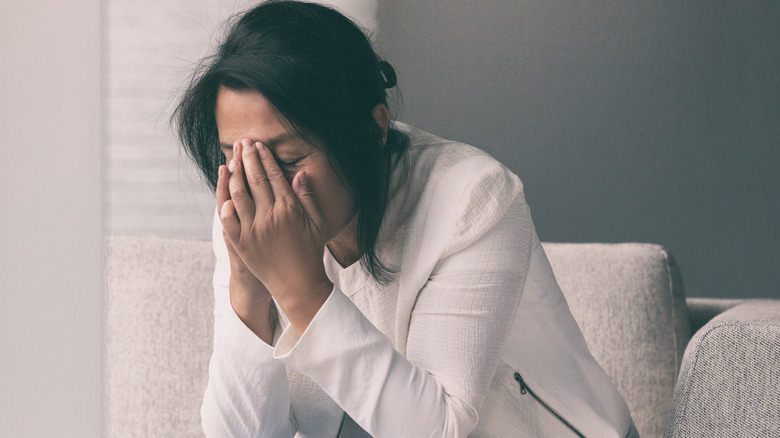 woman upset with her head in her hands