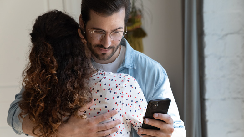 man secretly texting while he is with his girlfriend