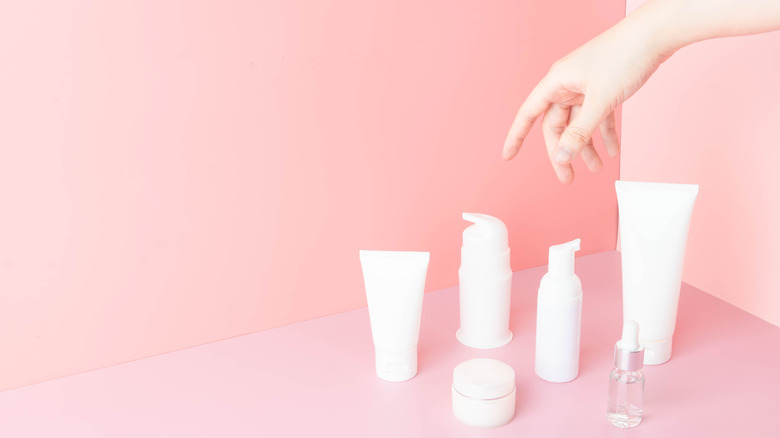 Different skincare products pictured against a pink background