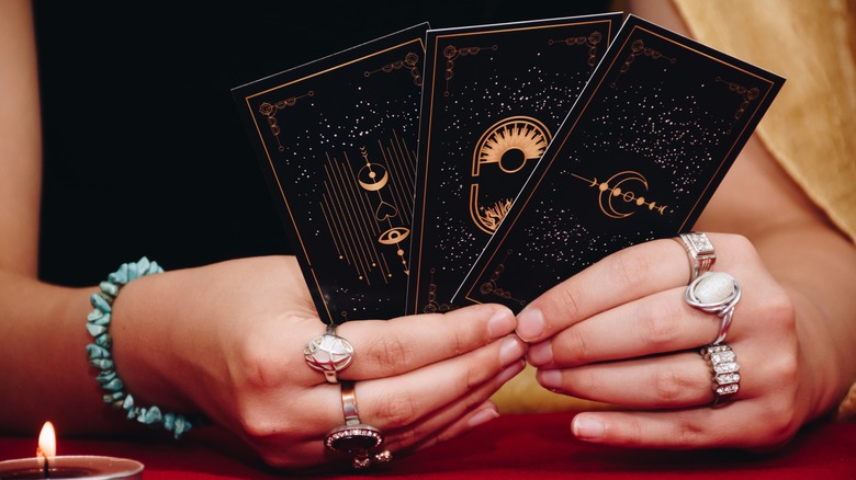 An astrologer holding tarot cards