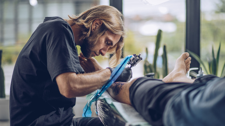 Tattoo artist hunched over 