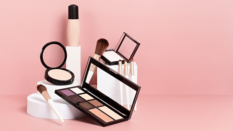 Various types of makeup displayed on a white podium