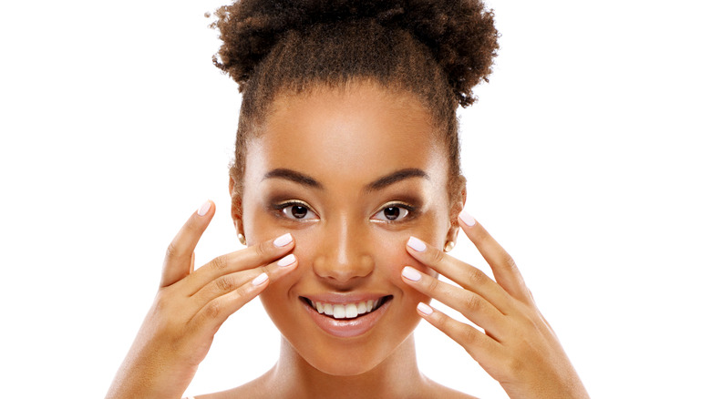 Woman applying a product to her cheeks