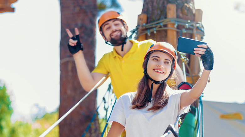 Couple taking selfies while zip lining