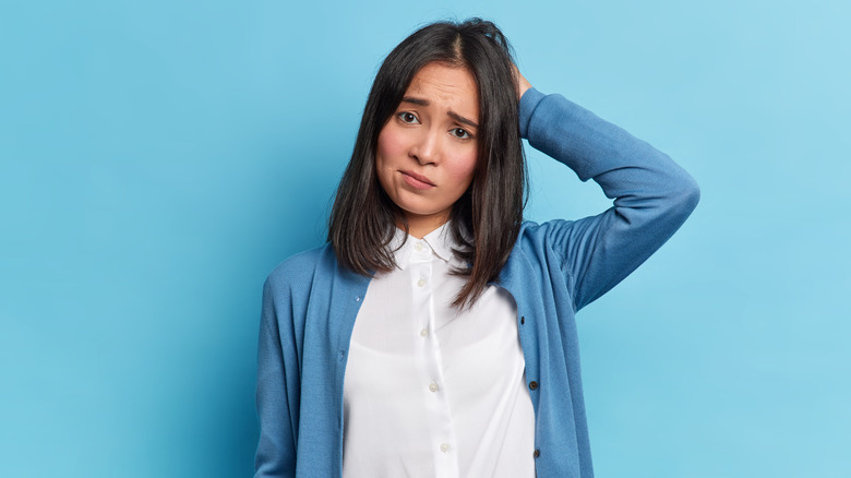 Confused woman scratching head