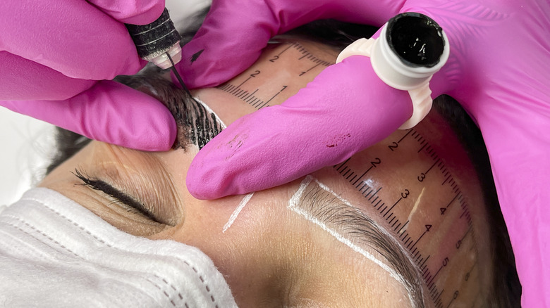 Beautician tattooing eyebrows