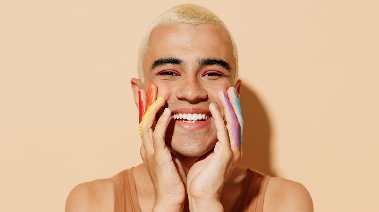 Happy blonde with rainbow-painted fingers 