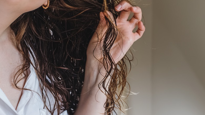 woman holding strand of curly wet hair
