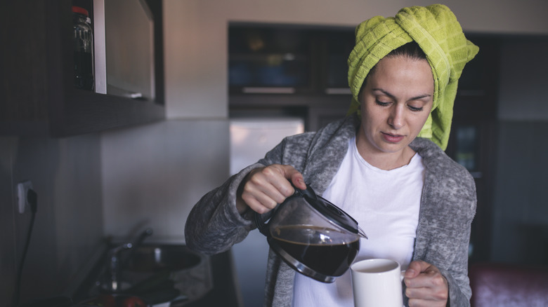 woman with hair in towel pouring coffee