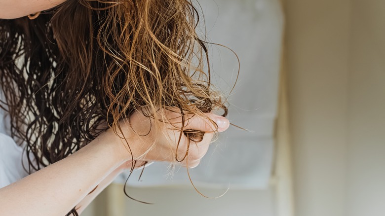 woman scrunching product into wet hair