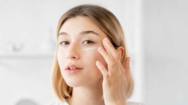 Woman applying moisturizer