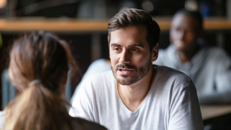 man and woman conversing at a table